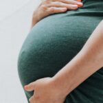 une femme enceinte se tient le ventre après un test ADN de paternité prénatal