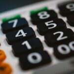 Gros plan sur les touches numérotées d'une calculatrice noire avec boutons colorés latéraux