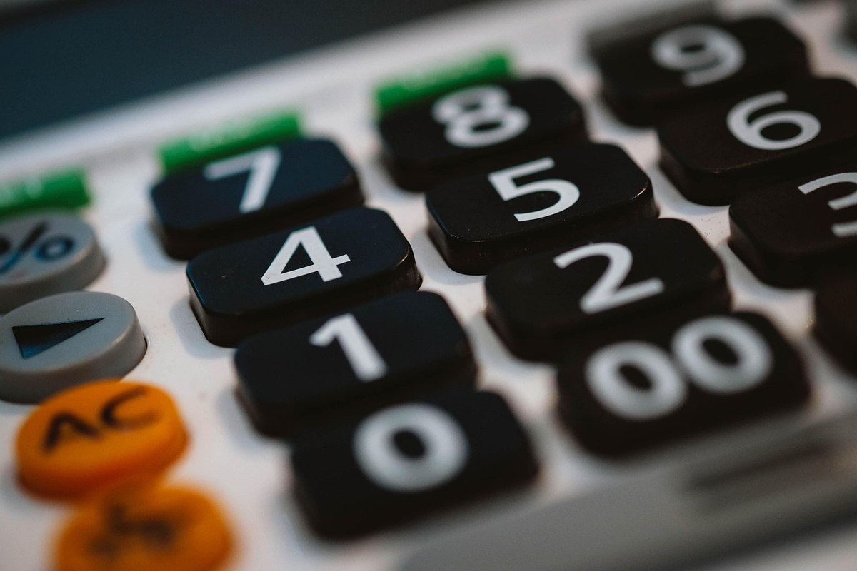Gros plan sur les touches numérotées d'une calculatrice noire avec boutons colorés latéraux
