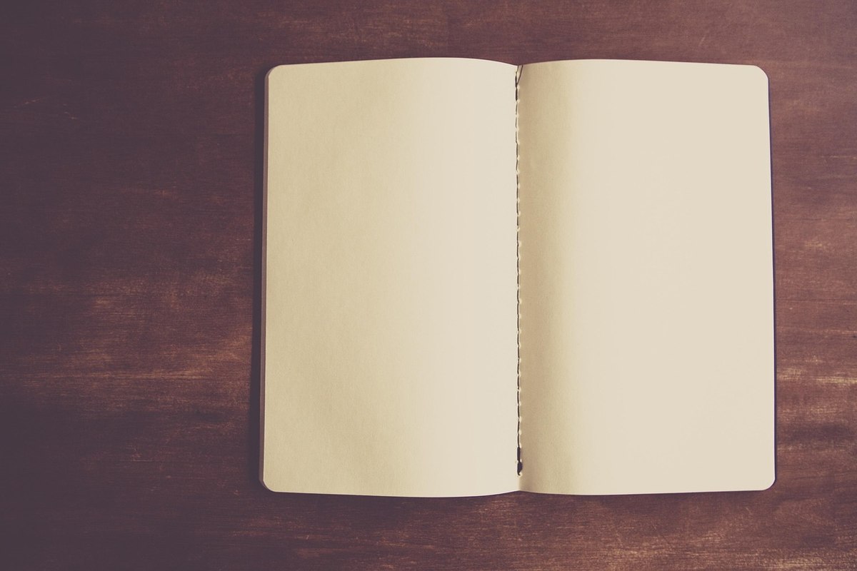 Un carnet vierge ouvert sur une surface en bois