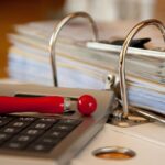Clavier de calcul, stylo rouge, classeur avec dossiers sur table