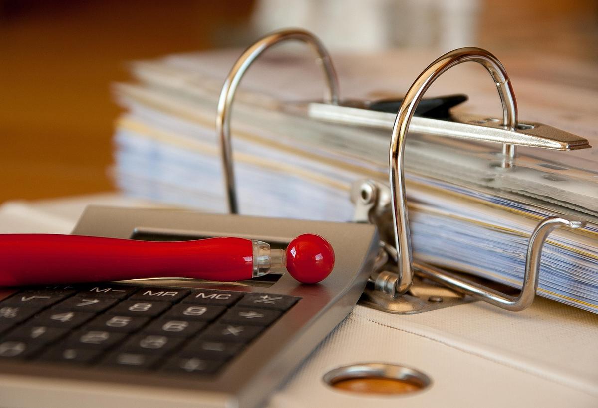 Clavier de calcul, stylo rouge, classeur avec dossiers sur table