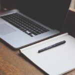 Ordinateur portable et cahier sur une table en bois
