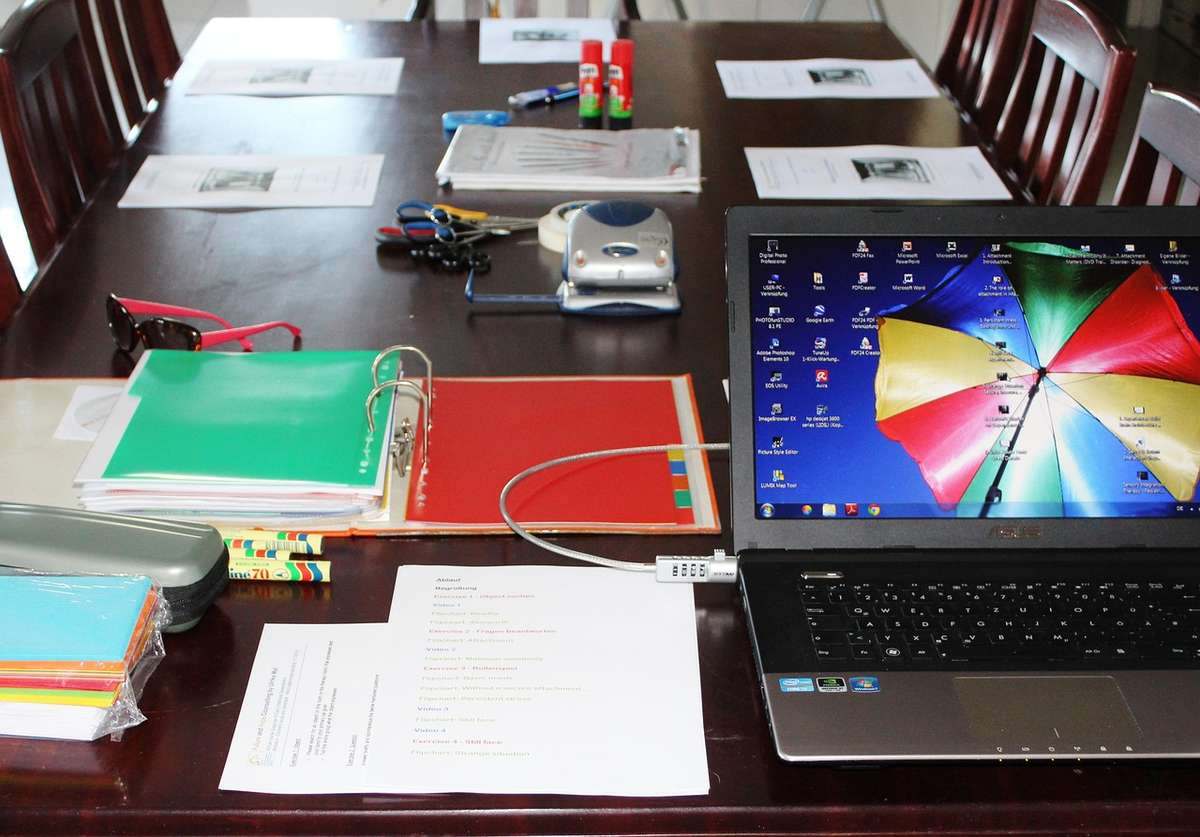 Ordinateur portable ouvert sur un bureau avec classeurs et documents Ordinateur portable ouvert sur un bureau avec classeurs et documents